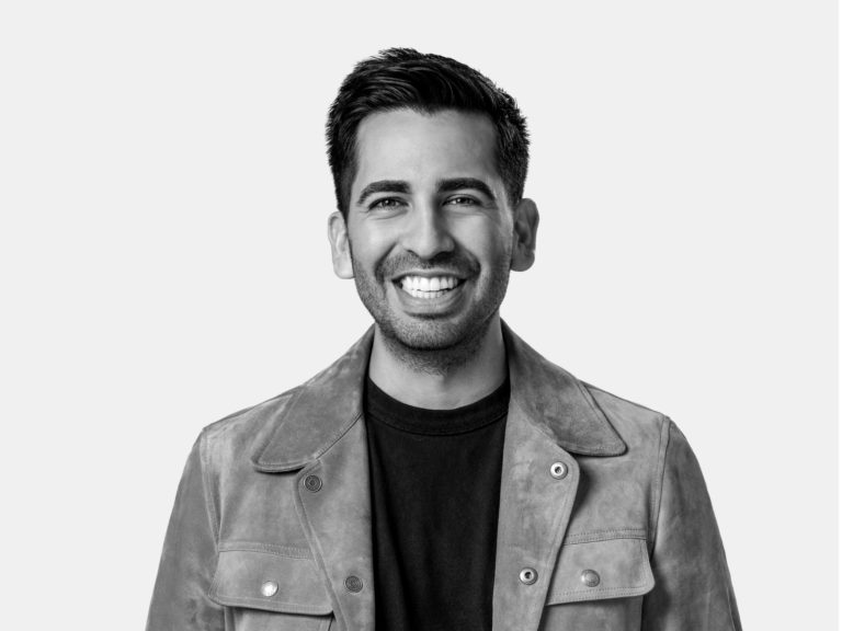 Black and white professional headshot of a young adult man against a plain white background